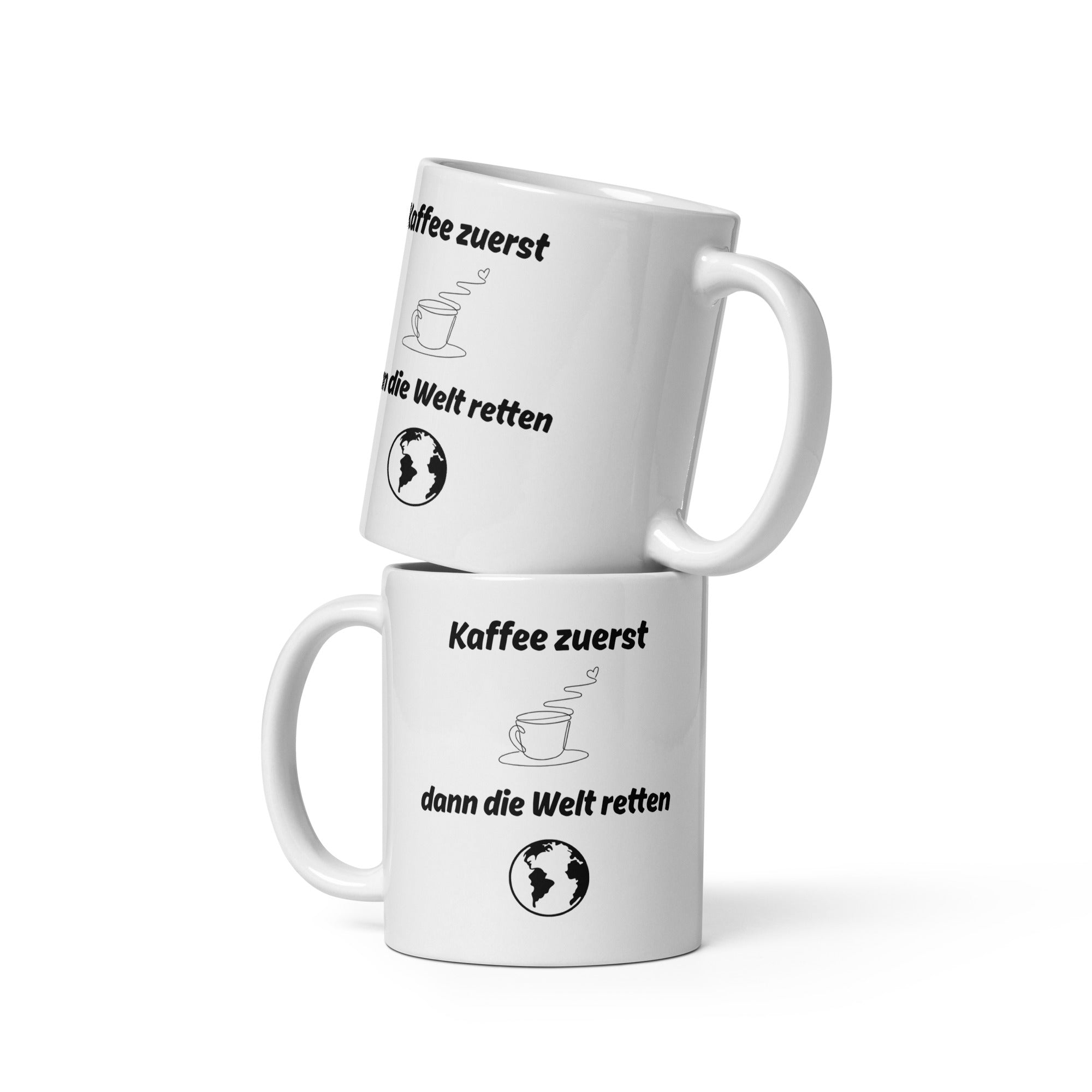 Zwei weiße Kaffeetassen mit schwarzem Aufdruck ‚Kaffee zuerst – dann die Welt retten‘, übereinander gestapelt.