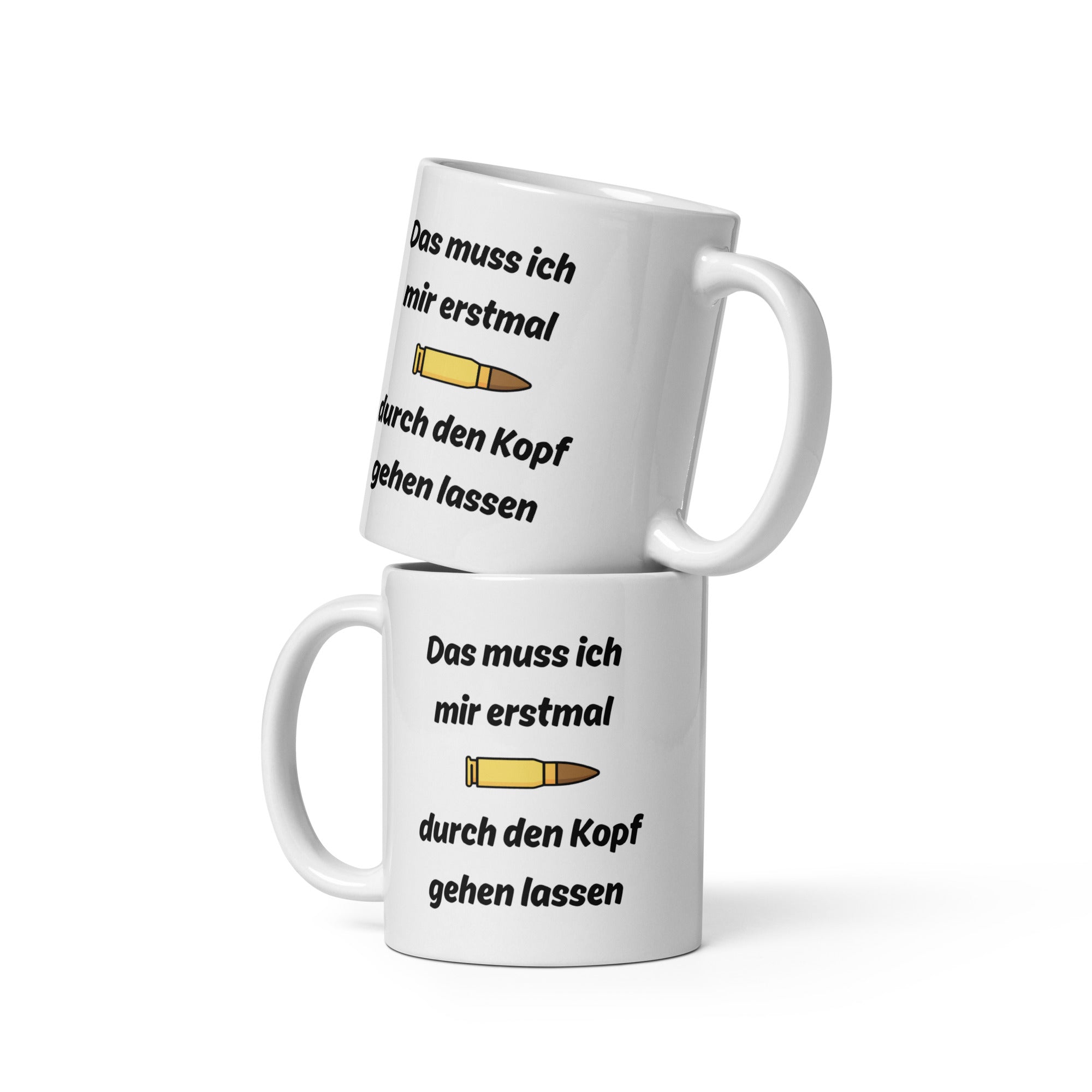 Zwei weiße Kaffeetassen mit schwarzer Aufschrift ‚Das muss ich mir erst mal durch den Kopf gehen lassen‘ und einer Patronen-Illustration, übereinander gestapelt.