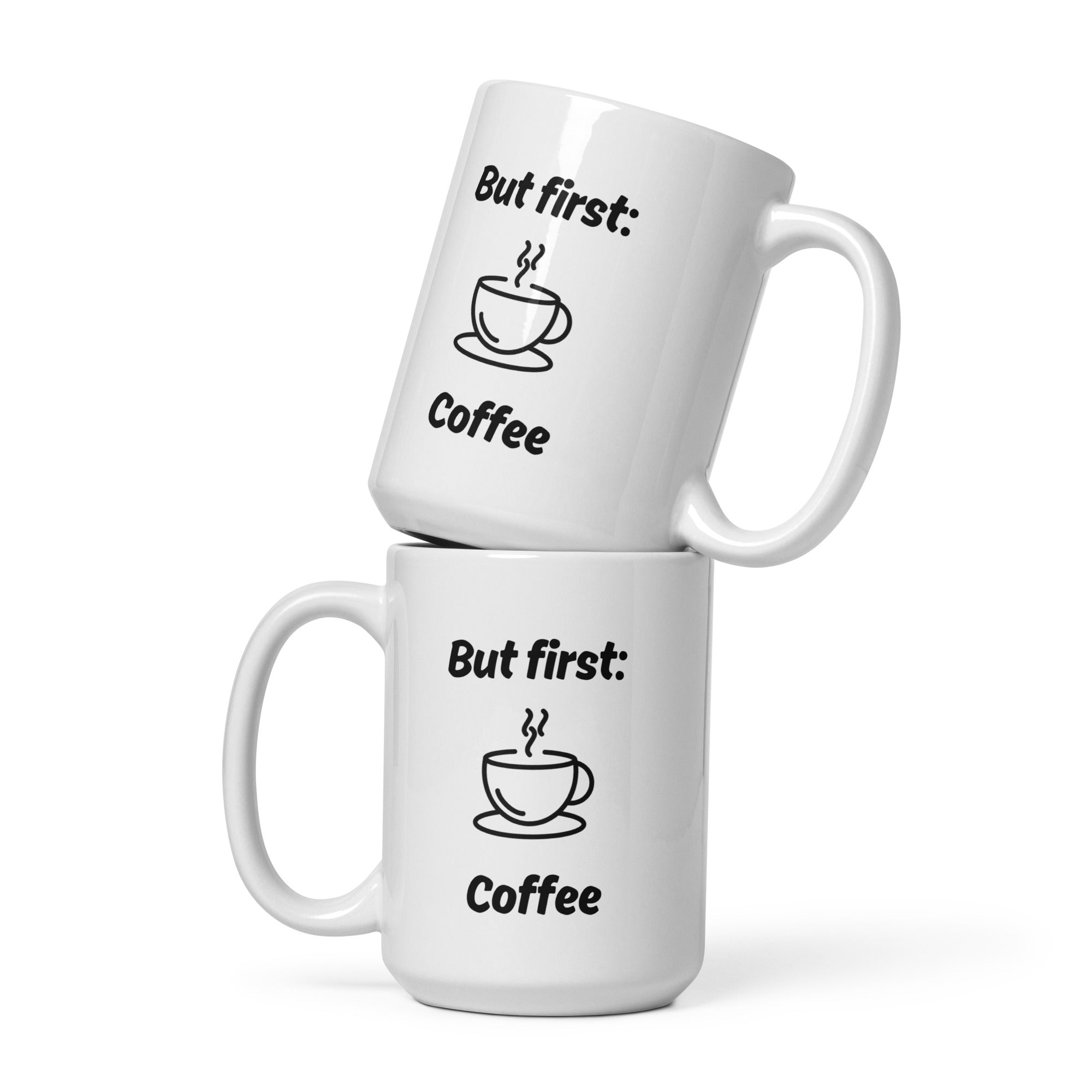 Zwei weiße Kaffeetassen mit schwarzer Aufschrift ‚But first: Coffee‘ und Illustration einer dampfenden Kaffeetasse, übereinandergestapelt.