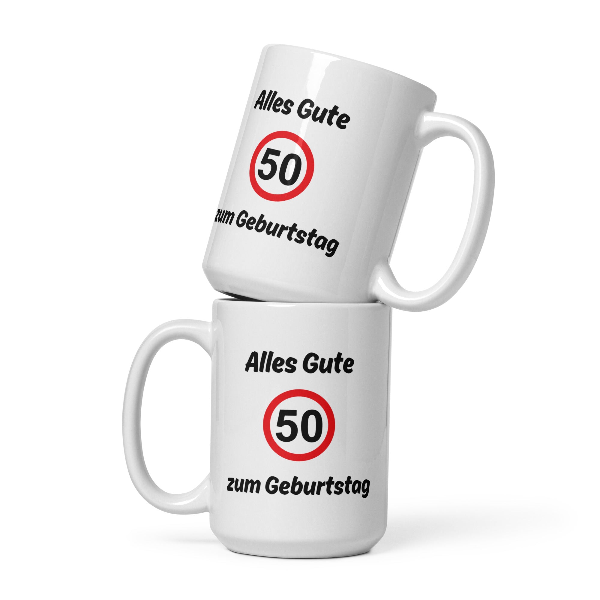 Zwei weiße Kaffeetassen mit schwarzer Aufschrift ‚Alles Gute zum Geburtstag‘ und rotem Verkehrszeichen mit der Zahl 50, übereinandergestapelt.