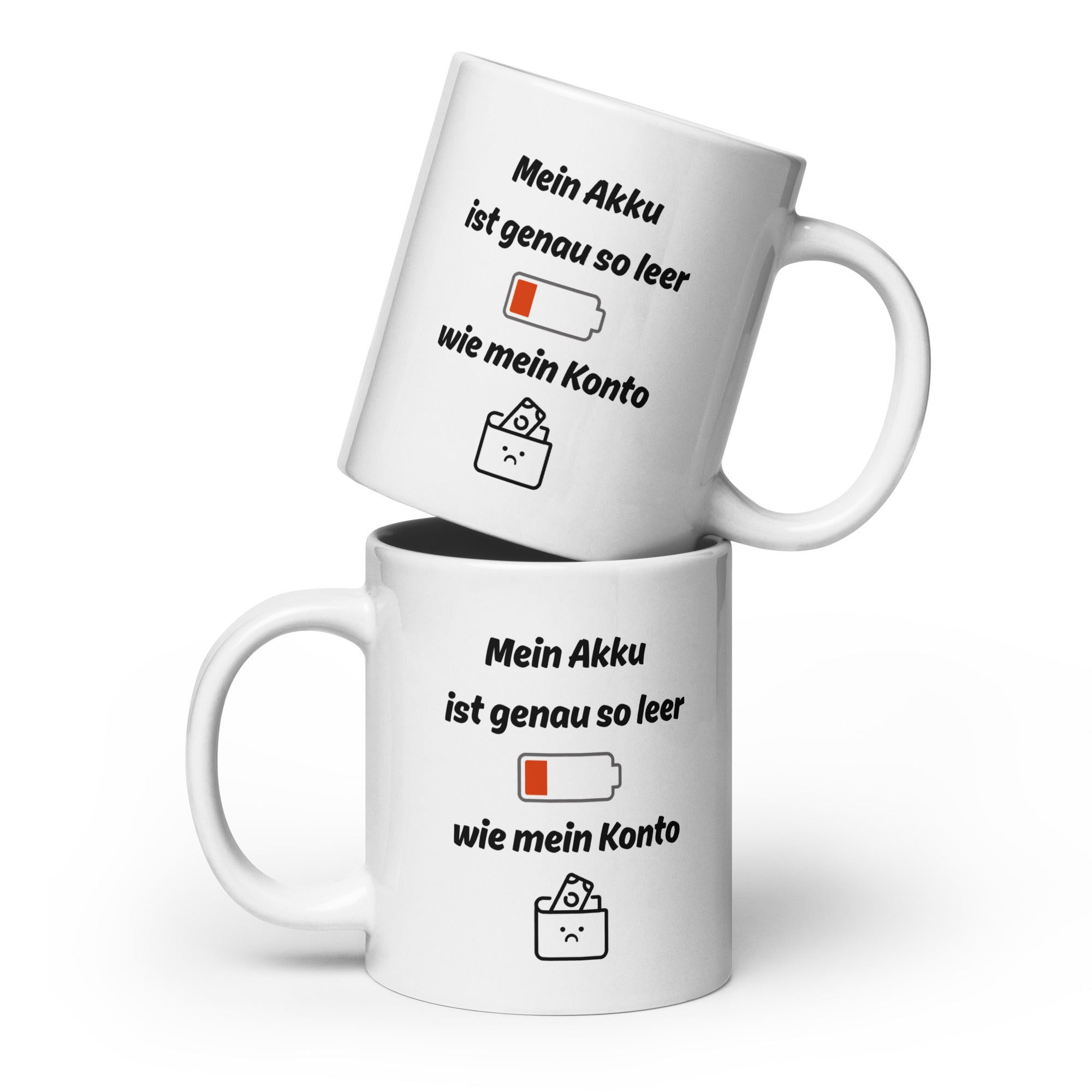 Zwei weiße Kaffeetassen mit schwarzer Aufschrift ‚Mein Akku ist genau so leer wie mein Konto‘, ergänzt durch Akku- und Geldbeutel-Illustration, übereinandergestapelt.